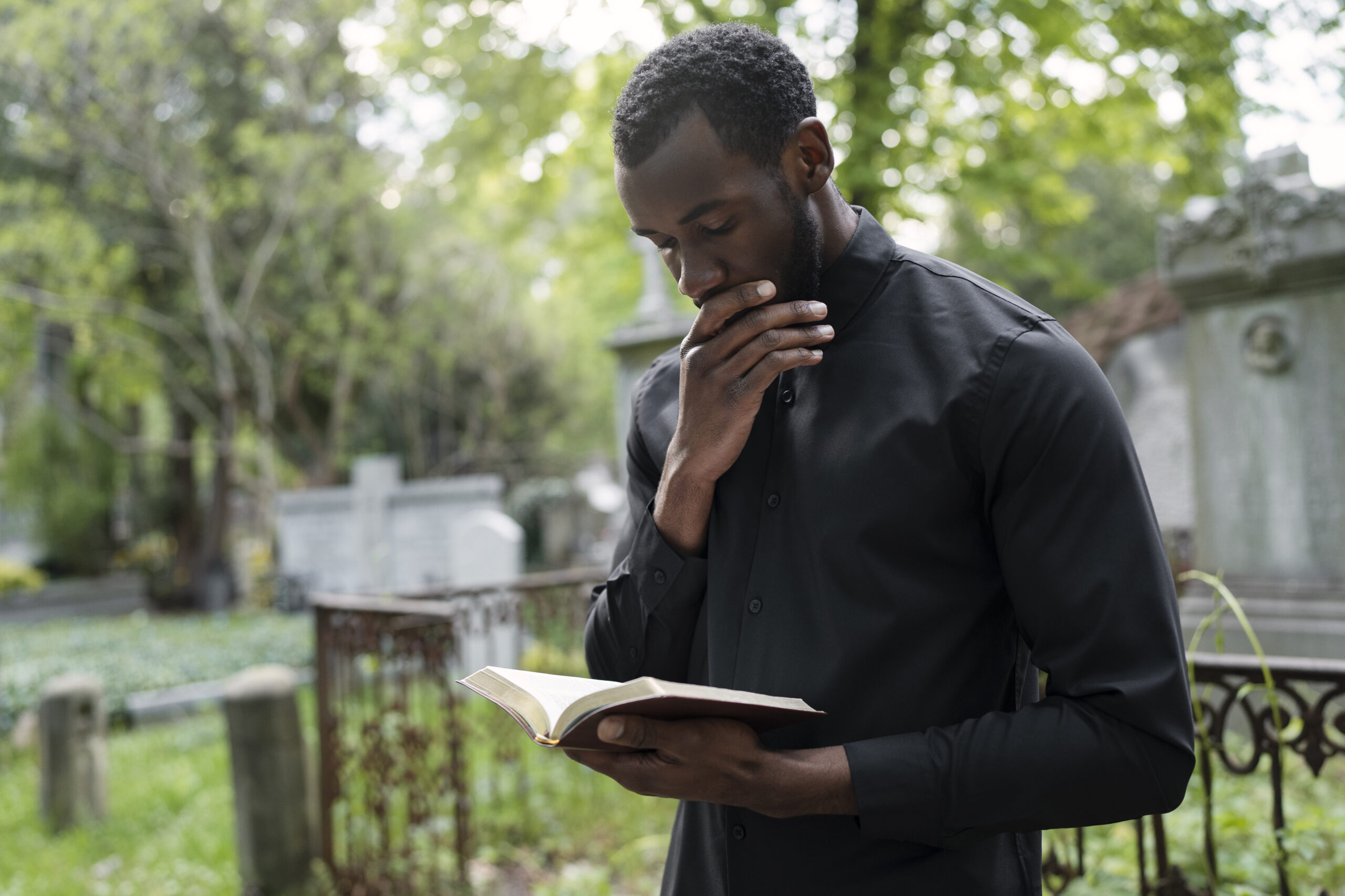 young-male-priest-holding-bible-cemetery The Testing of Our Faith